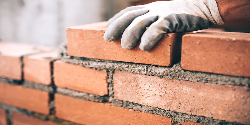 bricklayer-installing-brick-wall-representing-building-trust