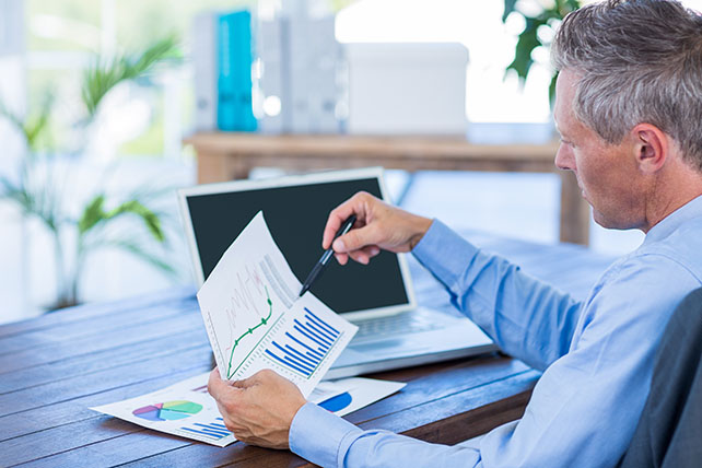 businessman-looking-at-documents-with-graphic