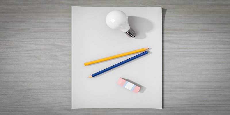 lightbulb pens and paper to signify ideas
