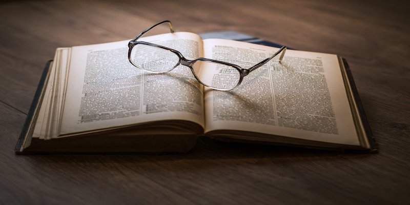 pair of glasses on a book to signify research