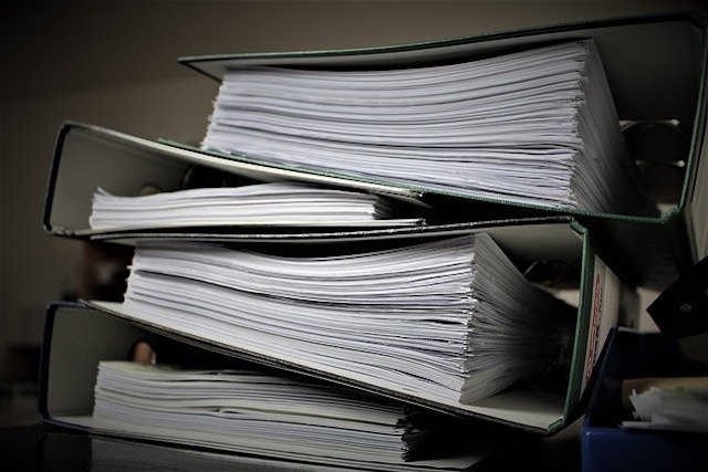 piles of paperwork from working on forensic accounting criminal cases alone feature