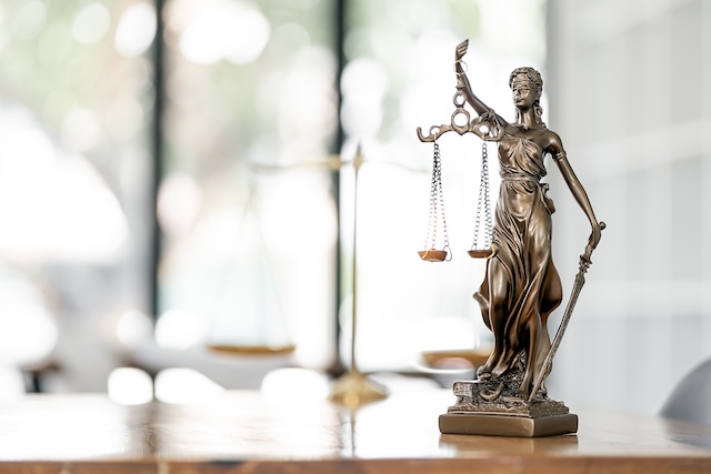 scales-of-justice-statue-on-wooden-desk-ccj-against-company-FEATURED-IMAGE