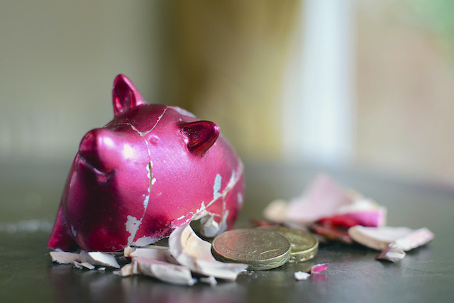 smashed-piggy-bank-with-pounds-on-table